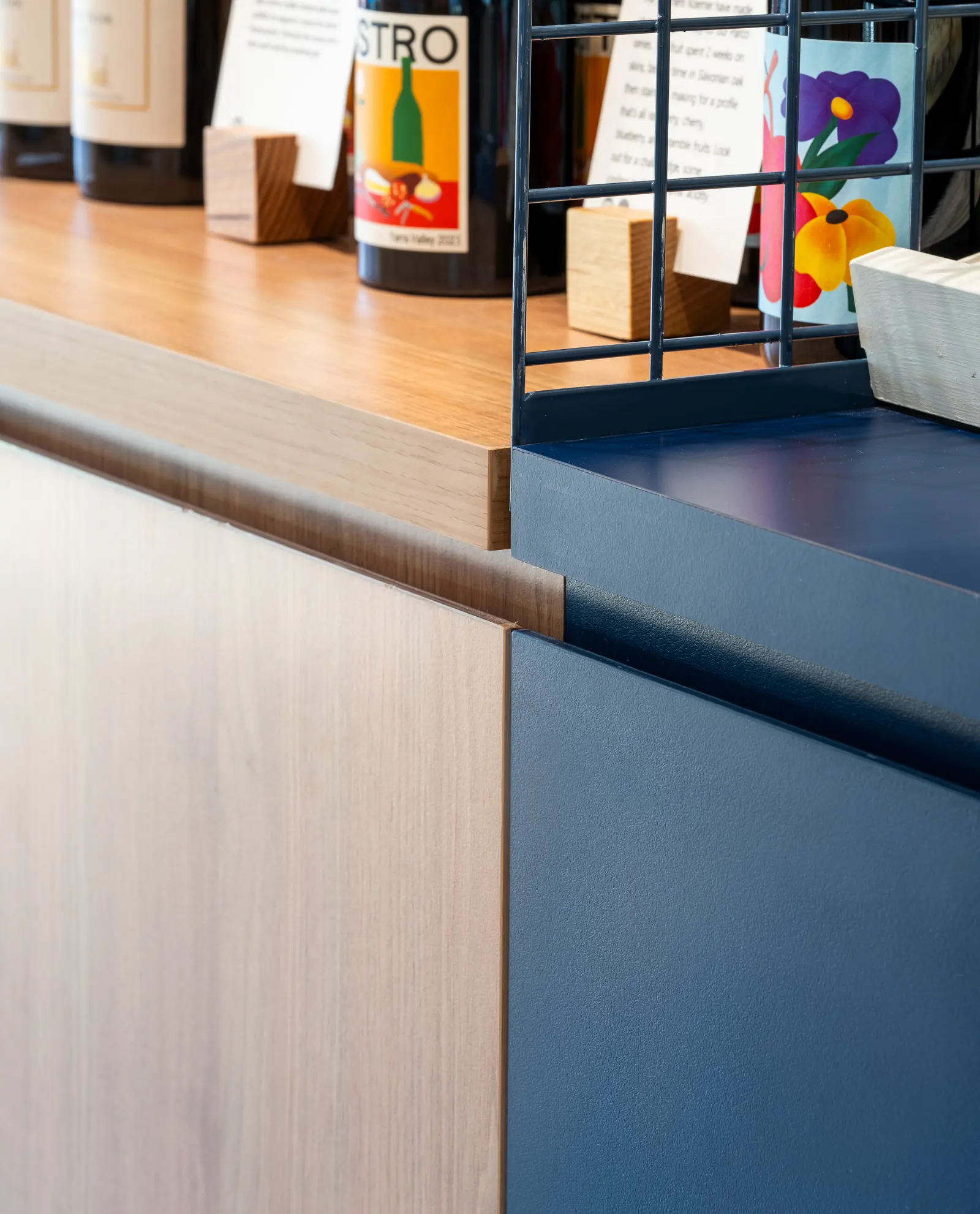 Timber joinery meeting a blue-painted counter panel