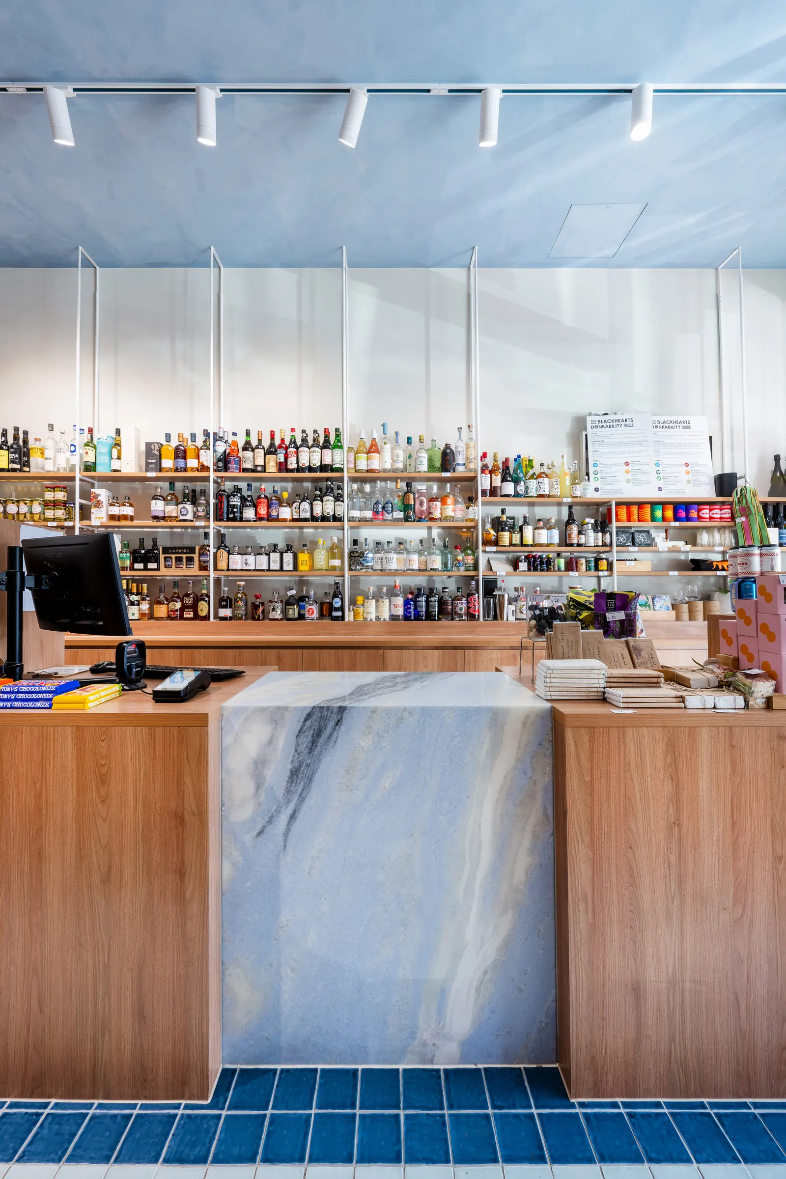Stone-clad service counter with timber joinery and blue tiles at its base