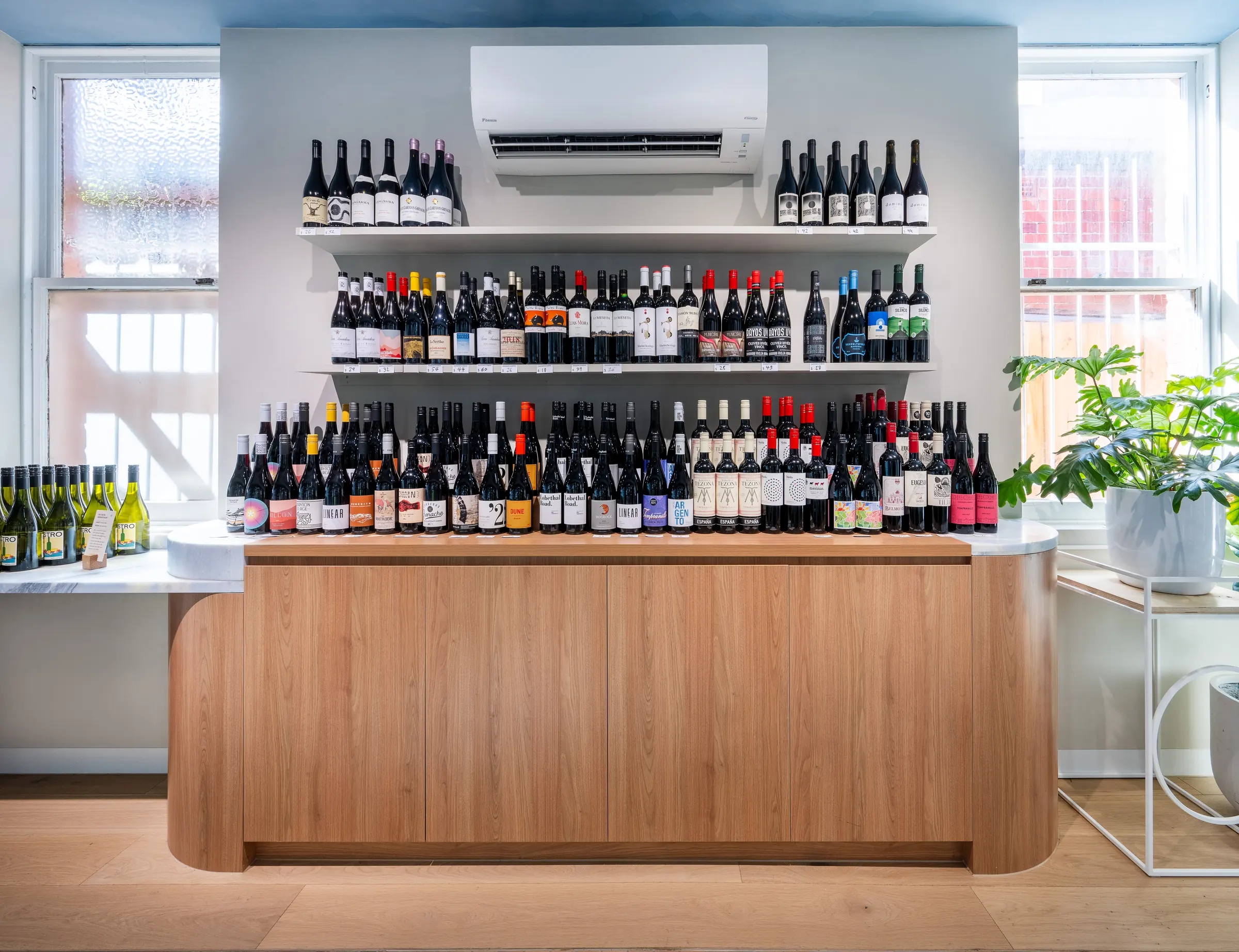 Timber counter with a rounded end below the wine display wall