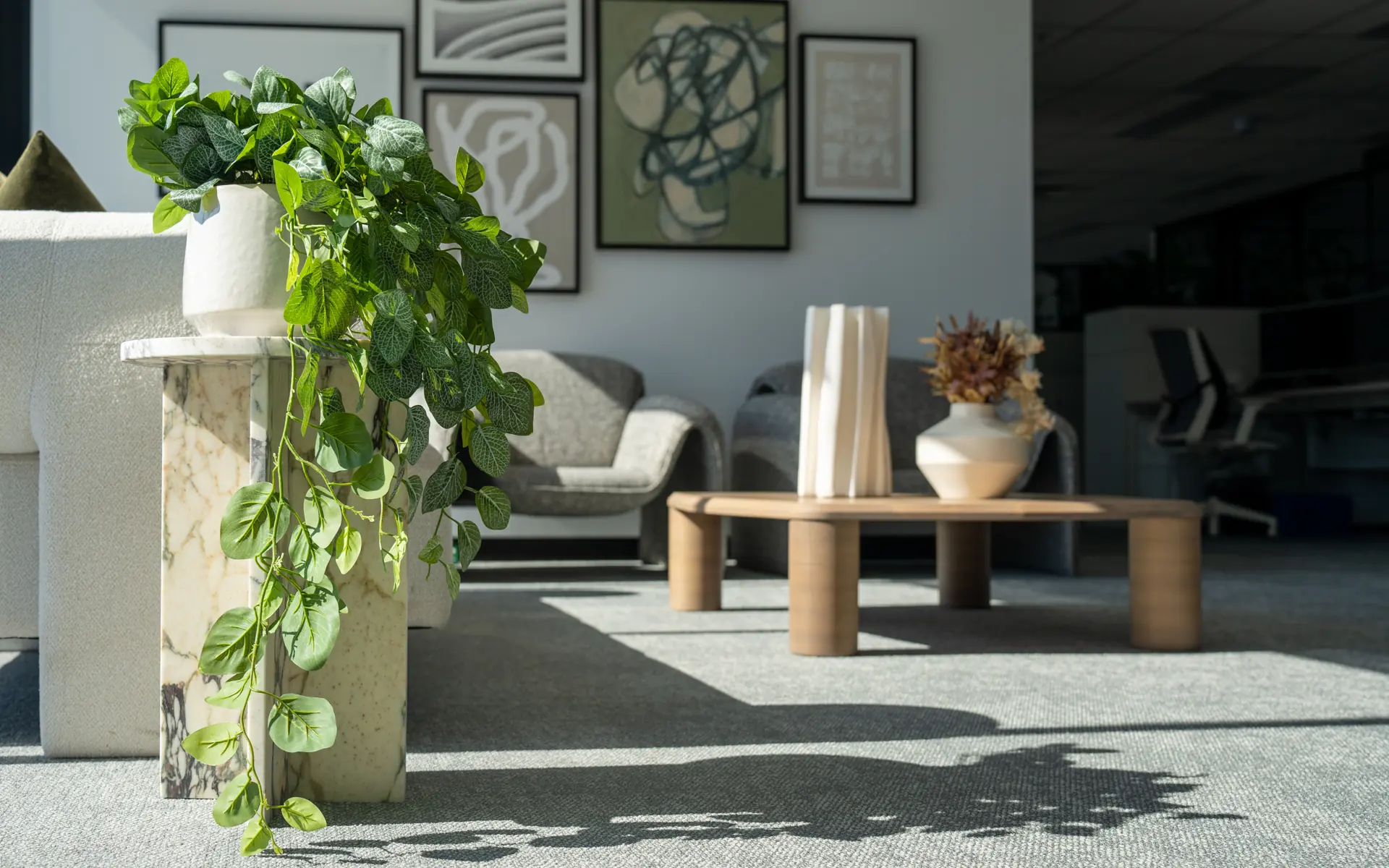 Lounge area with low timber tables, planting and upholstered seating