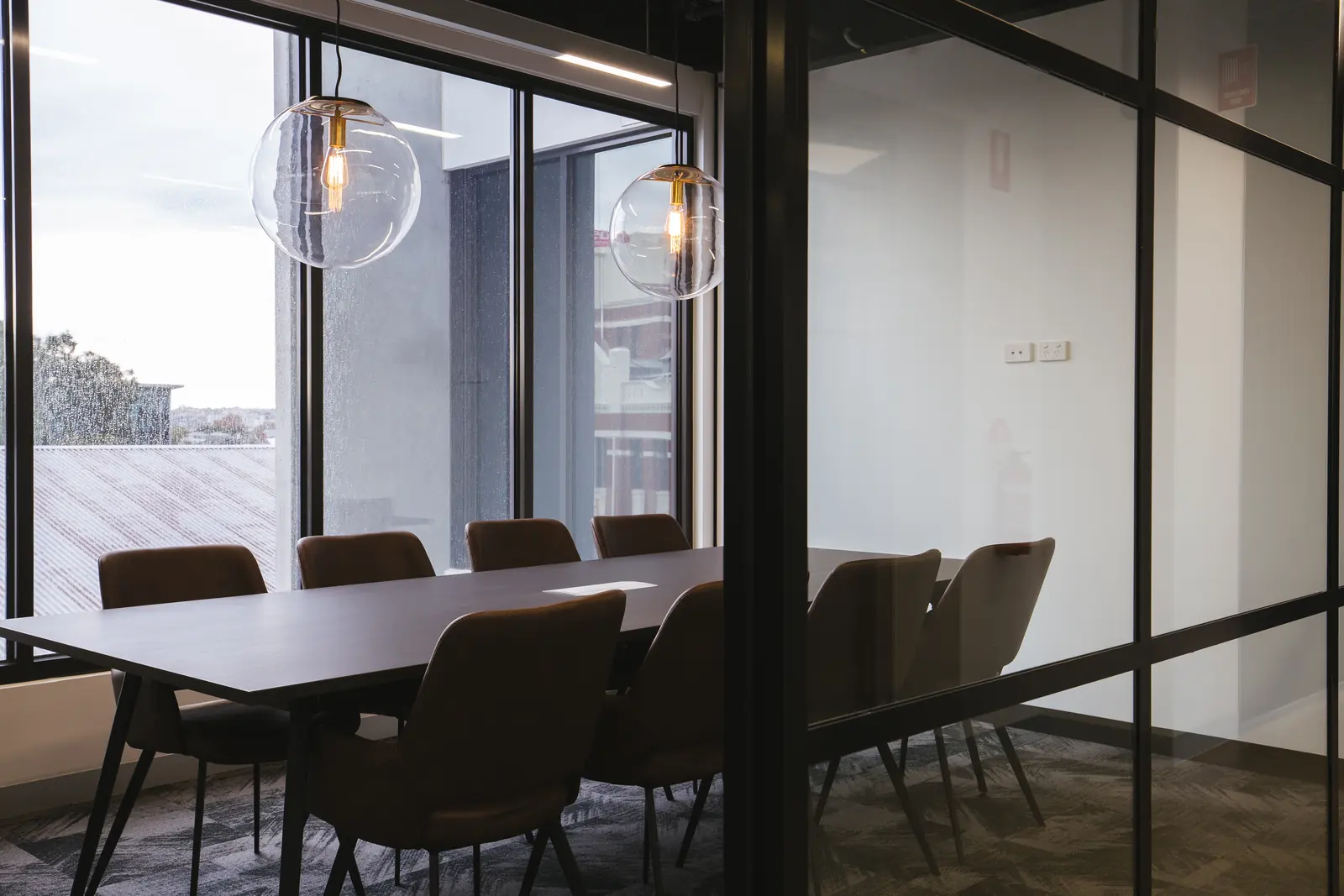 Boardroom table with leather chairs and a view to the terrace