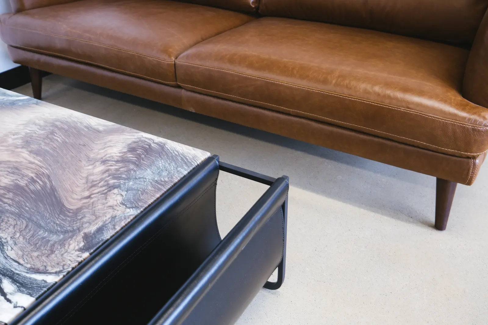 Leather sofa and marbled stone table top with a black steel frame