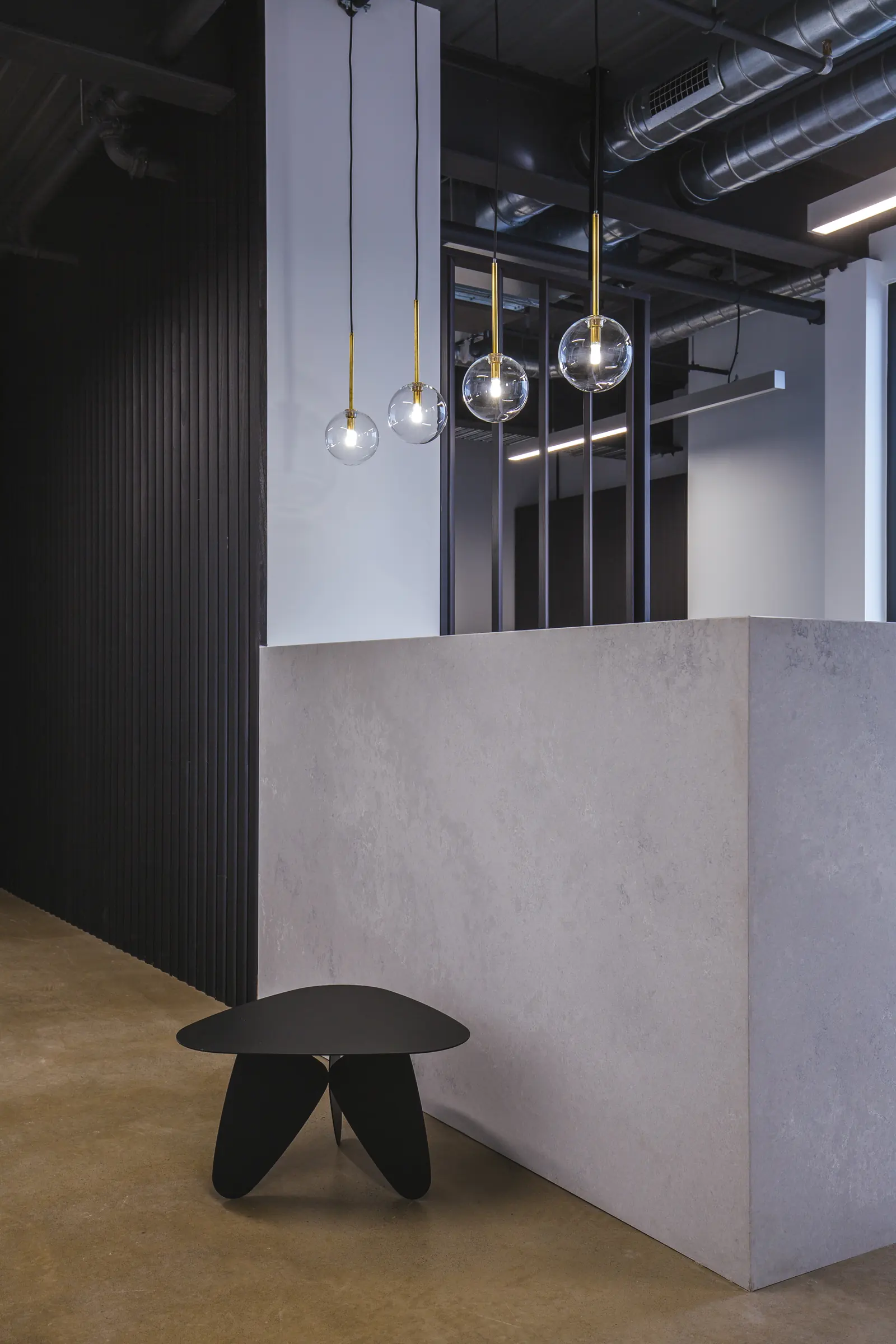 Stone reception block with glass pendant lights and a dark timber wall