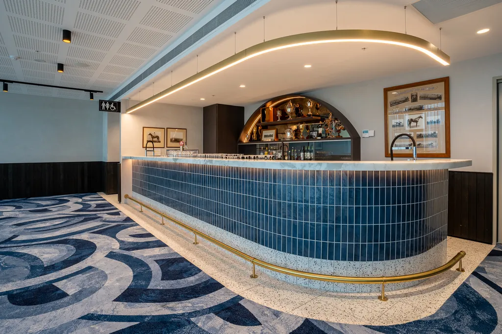 Curved bar with a blue tiled front, brass footrail and patterned carpet